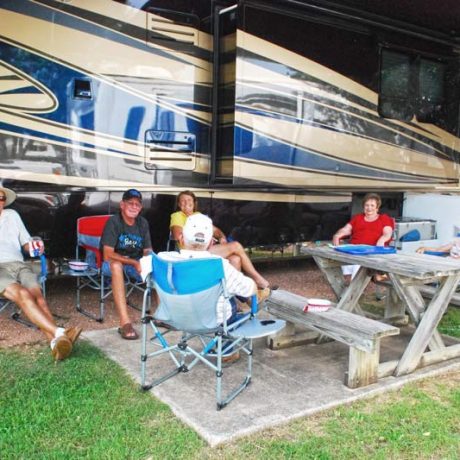 people sitting together outside an RV