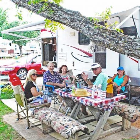 people sitting together outside of an RV